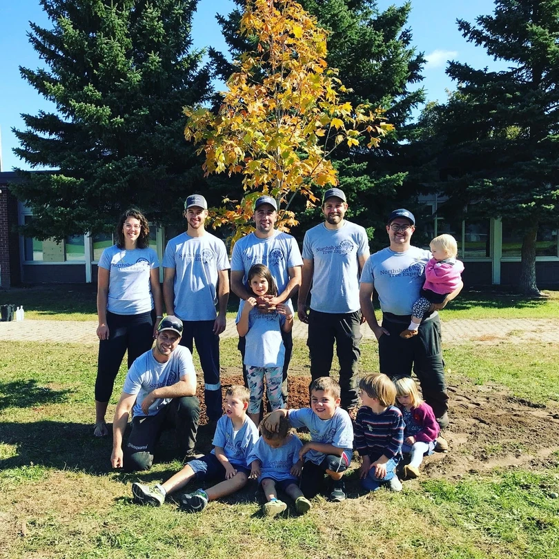 Family planting a tree together in a garden